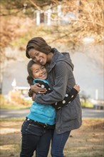 Portrait of smiling Mixed Race sisters hugging outdoors