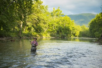 Caucasian man fishing in river