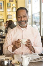 Mixed Race man drinking coffee in coffee shop