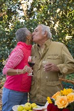 Couple drinking wine and kissing outdoors