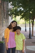 Portrait of Asian mother and son standing on sidewalk