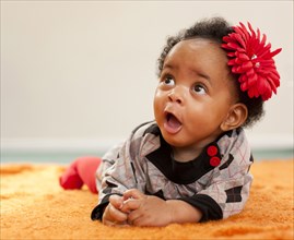 African American baby girl with red flower in her hair