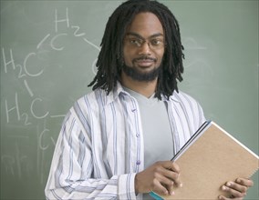 Portrait of male teacher with notebooks