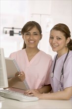 Portrait of two nurses in front of computer