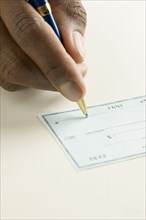 Close up of hand writing check
