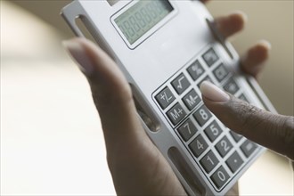 Close up of hands holding calculator