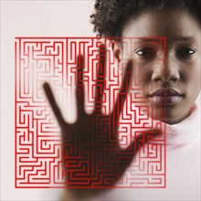 Portrait of woman holding hand on glass with maze