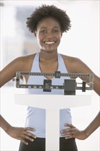 Portrait of woman weighing herself on scale