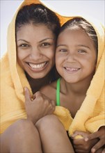 Portrait of mother and daughter wrapped in towel