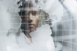 Portrait of man looking through globe