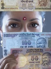 Woman in traditional Indian dress holding Indian money
