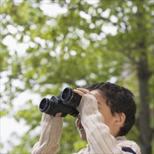 Boy using binoculars outdoors