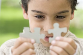 Boy fitting puzzle pieces together