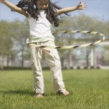 Young girl rotating a hula hoop