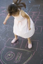 Overhead view of girl playing hopscotch