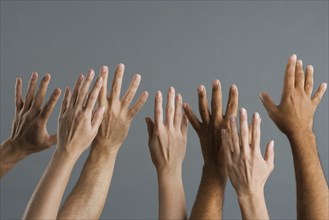 Close up of group of hands raised