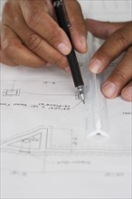 Close up of hands drawing plans with ruler