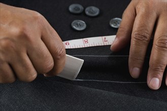 Close up of hands measuring with tape measure