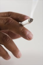 Close up of hand holding cigarette