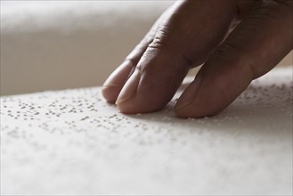 Close up of hand reading Braille