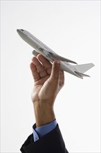 Close up of hand holding toy airplane in air