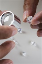 Close up of hands examining diamonds