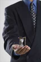 Close up of businessman's hands holding hour glass