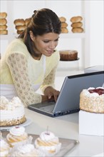 Woman at bakery working on laptop