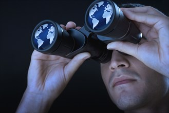 Close up of man looking at world through binoculars