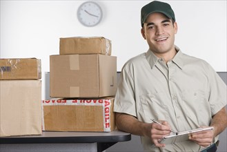 Portrait of delivery man with stack of boxes