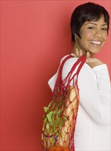 Side view portrait of woman with grocery bag over shoulder