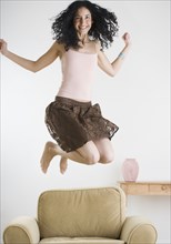 Young woman jumping on the couch