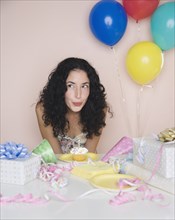 Young woman blowing out candle on birthday cupcake