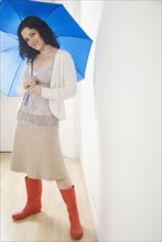 Portrait of woman with umbrella and rubber boots