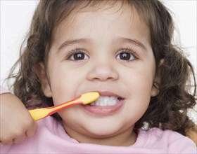 Close up portrait of little girl brushing teeth