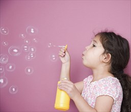 Girl blowing bubbles with wand