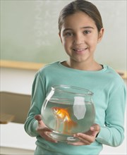 Young girl holding a fishbowl