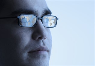 Businessman's glasses reflecting a globe