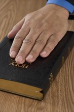 Close up of male hand on bible
