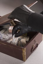 Close up of gloved hands taking jewels out of box