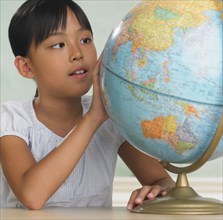 Asian girl looking at globe