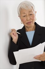 Senior Asian businesswoman reading paperwork