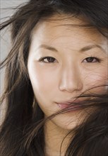 Close up of young Asian woman with hair in face