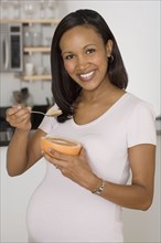 Pregnant African woman eating grapefruit