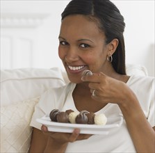 African woman eating chocolate truffles