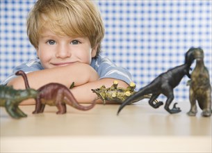 Portrait of young boy with toy dinosaurs