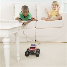 Two young boys playing with remote control car