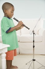 African boy playing a recorder with sheet music