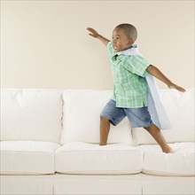 Young African boy playing on sofa