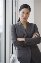 Middle-aged Asian businesswoman with arms crossed